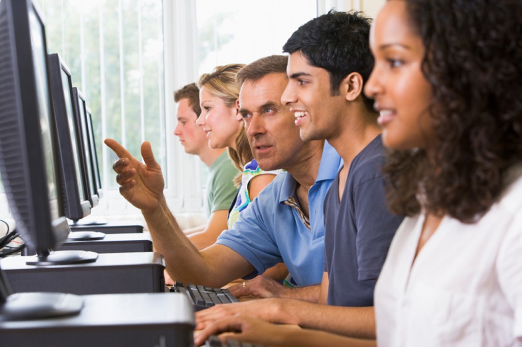 Teacher assisting college student in a computer lab | Horizon DataSys ...